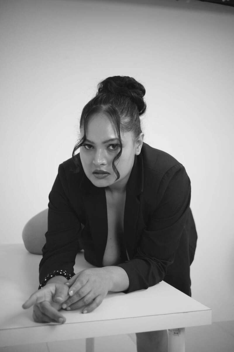 Close intense gaze of the model resting on a table, black and white