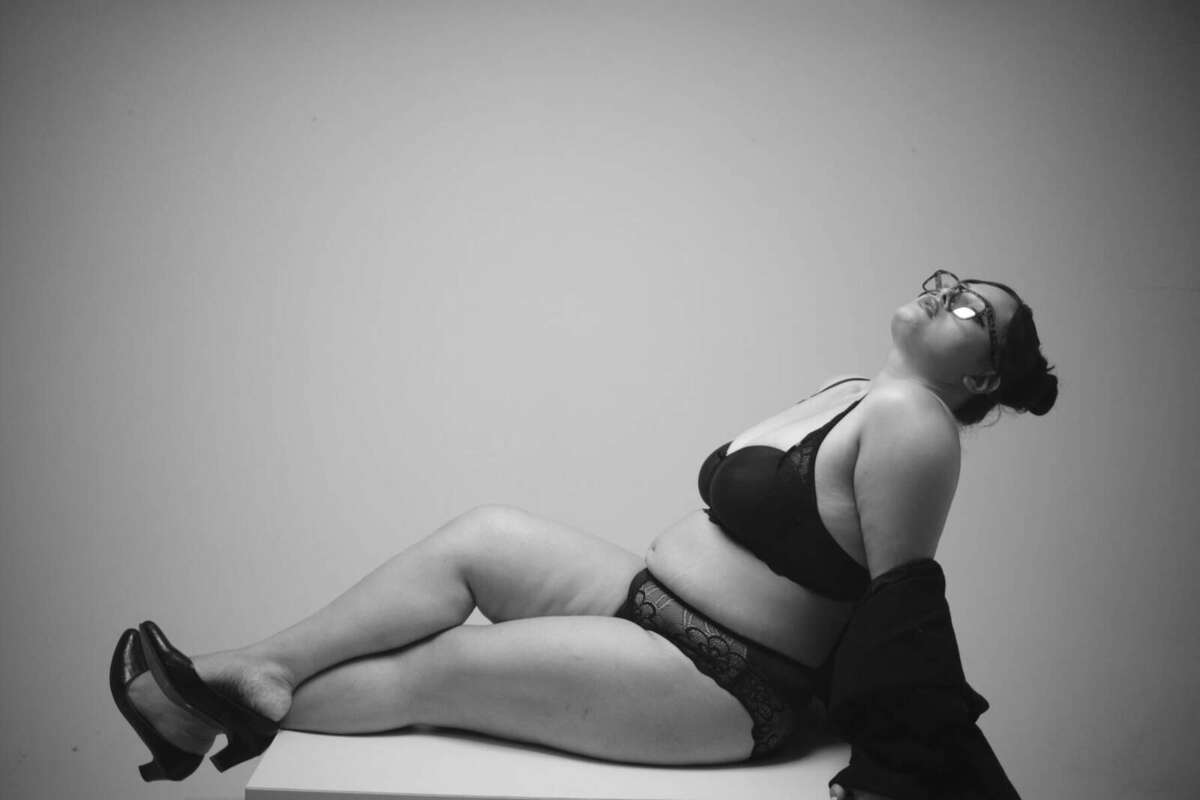 Model reclining across a white table, black and white