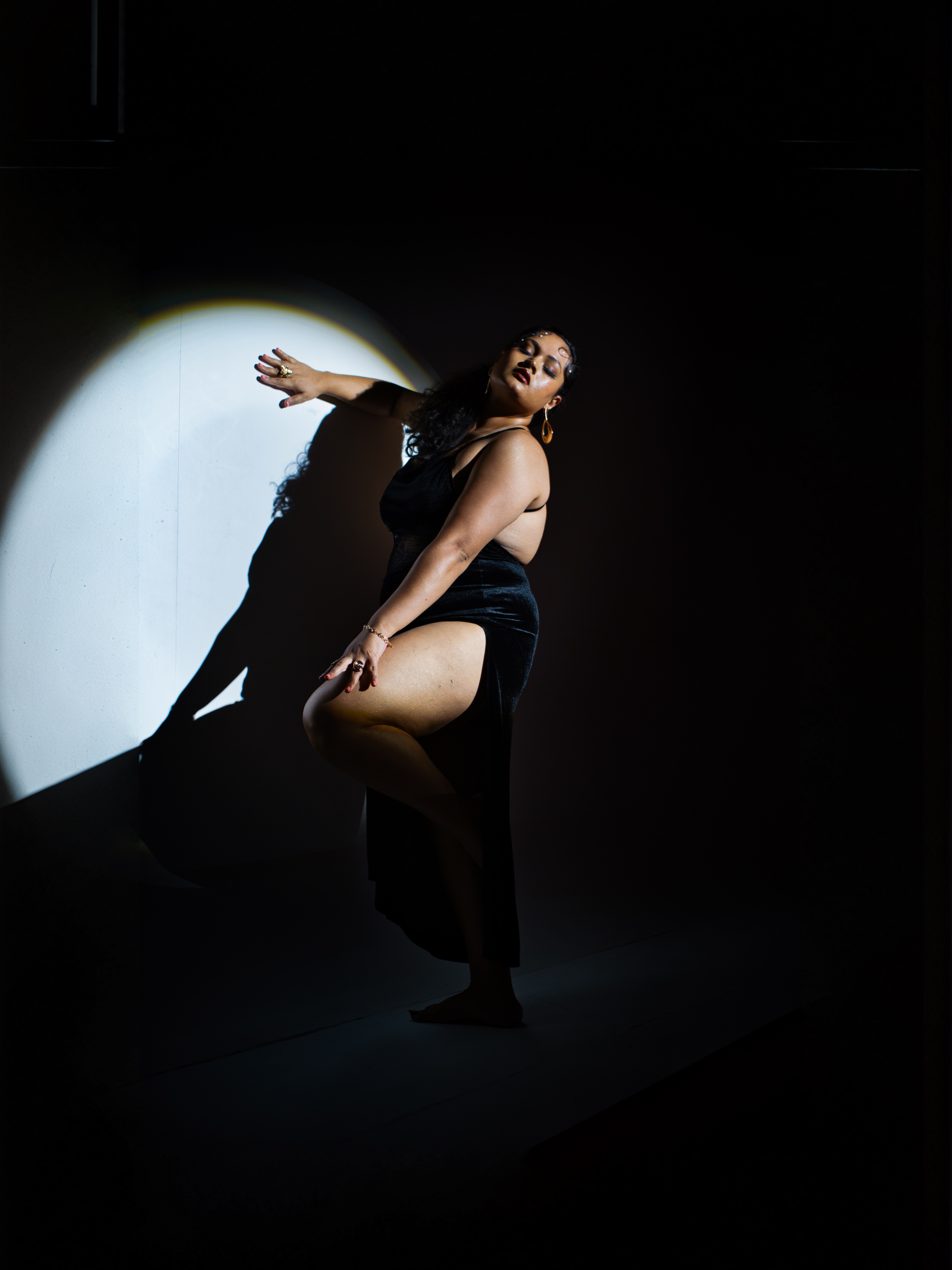 Model in a dramatic spotlight, dance-inspired studio pose
