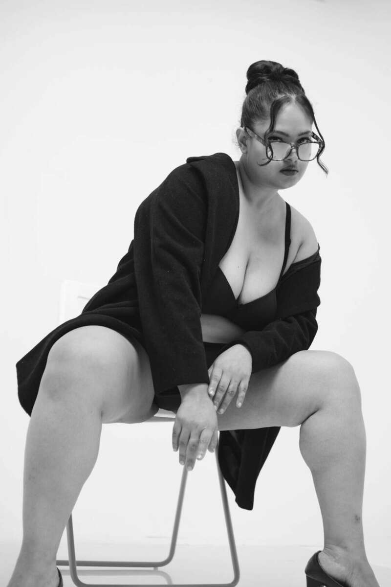 Model pointing directly at the camera, high-key black and white